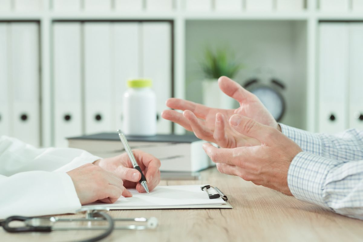 Médecin et patient en consultation, échange autour d’un document